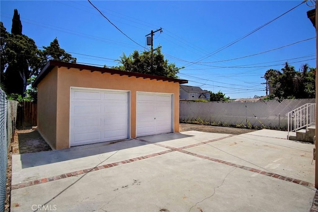 detached garage featuring fence