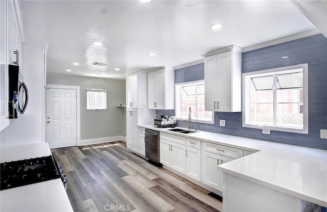 kitchen with white cabinets, light countertops, a sink, and dishwasher