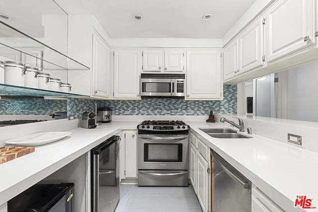 kitchen featuring sink, white cabinetry, stainless steel appliances, and tasteful backsplash