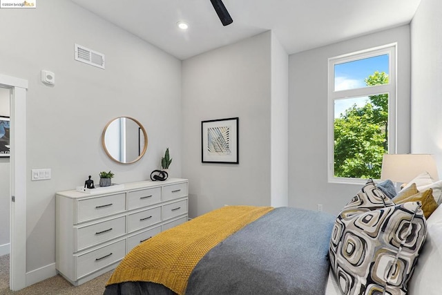 carpeted bedroom with multiple windows and ceiling fan