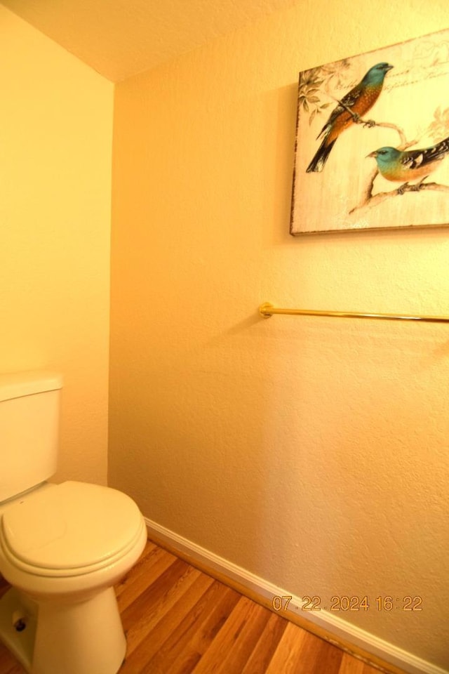 bathroom with wood-type flooring and toilet