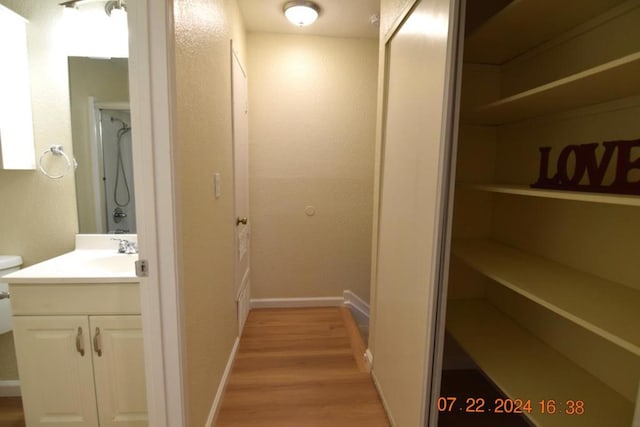 corridor featuring sink and light hardwood / wood-style flooring