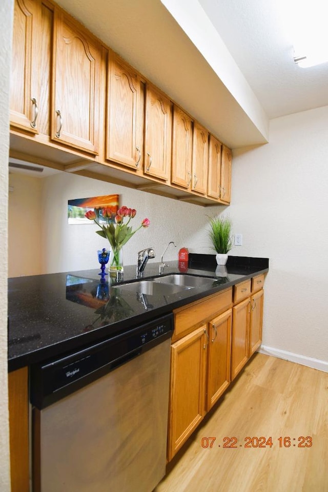 kitchen featuring sink, stainless steel dishwasher, and light hardwood / wood-style floors