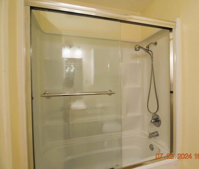 bathroom featuring bath / shower combo with glass door