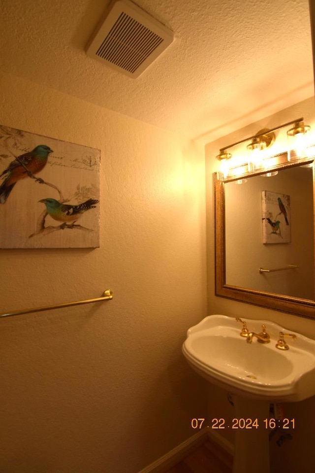 bathroom featuring sink and a textured ceiling