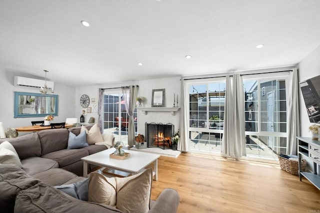 living room featuring a fireplace, light hardwood / wood-style flooring, and a healthy amount of sunlight