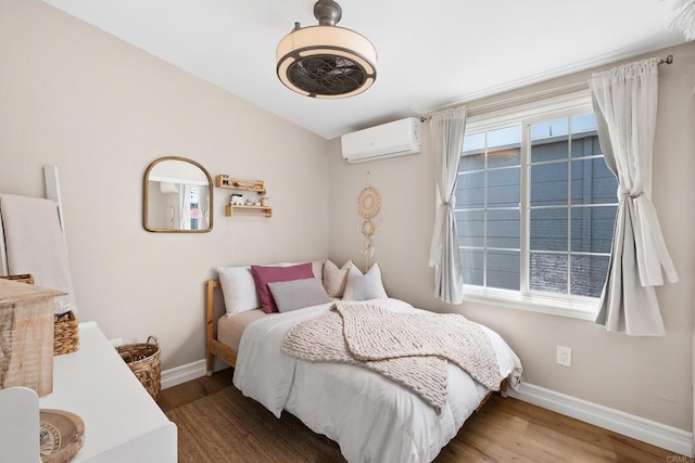 bedroom with wood-type flooring and a wall unit AC