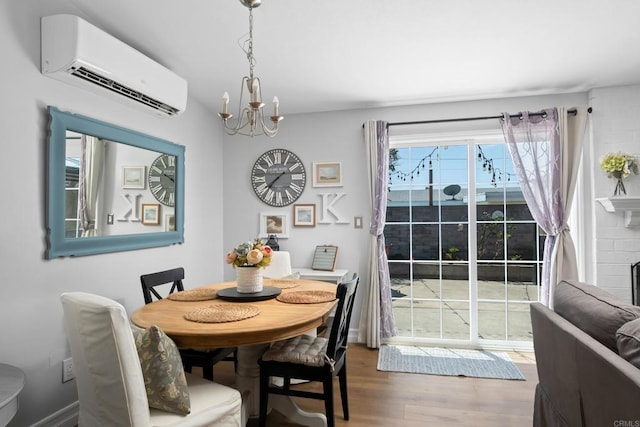 dining room featuring a fireplace, wood-type flooring, an AC wall unit, and an inviting chandelier