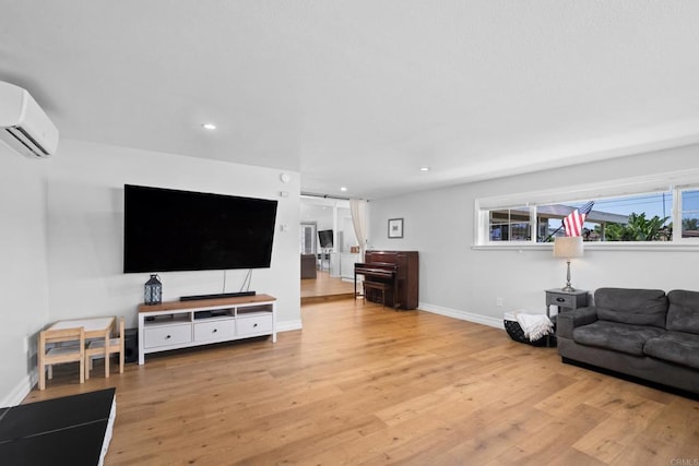 living room with light hardwood / wood-style flooring and a wall mounted AC