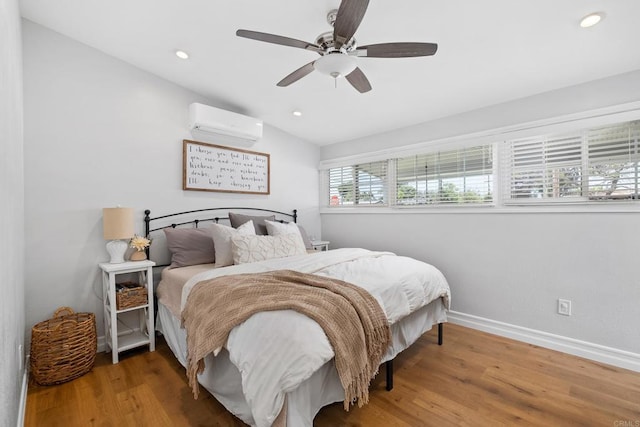 bedroom with ceiling fan, vaulted ceiling, hardwood / wood-style flooring, and a wall unit AC