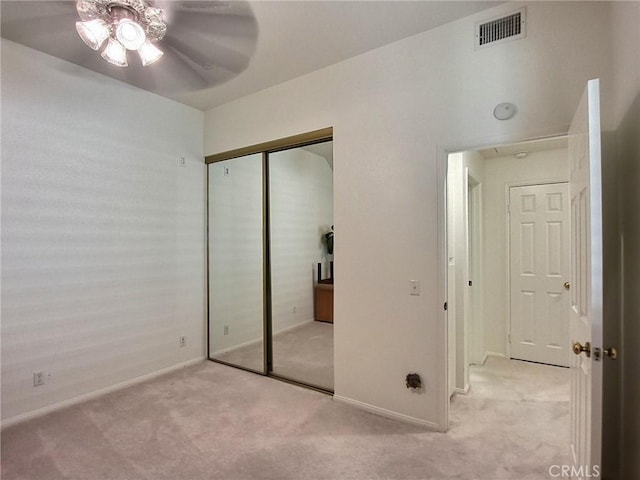 unfurnished bedroom with light carpet, baseboards, visible vents, and a closet