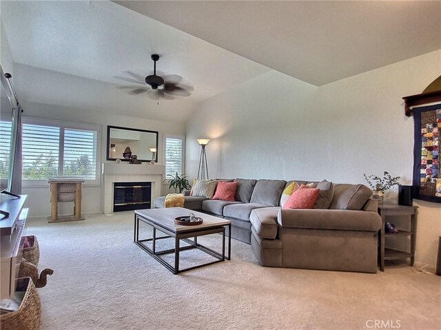 living area with carpet, ceiling fan, lofted ceiling, and a tiled fireplace