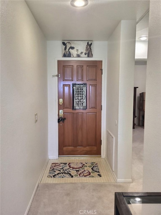 entryway featuring light carpet, baseboards, and visible vents