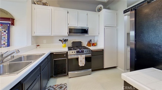 kitchen with light countertops, appliances with stainless steel finishes, and white cabinetry