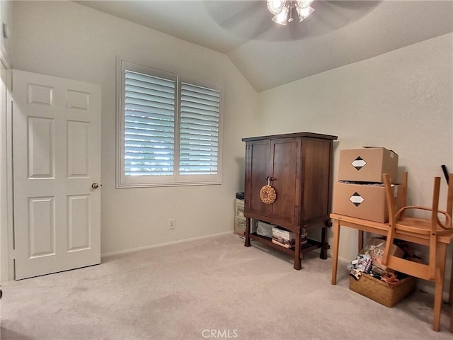 interior space with vaulted ceiling, light carpet, a ceiling fan, and baseboards