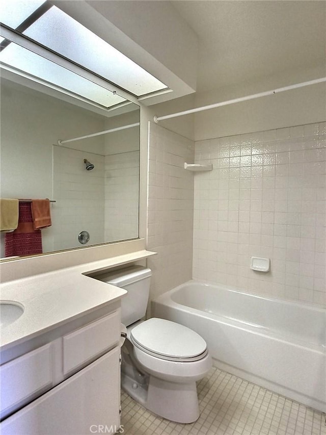 bathroom with a skylight, toilet, tub / shower combination, vanity, and tile patterned floors