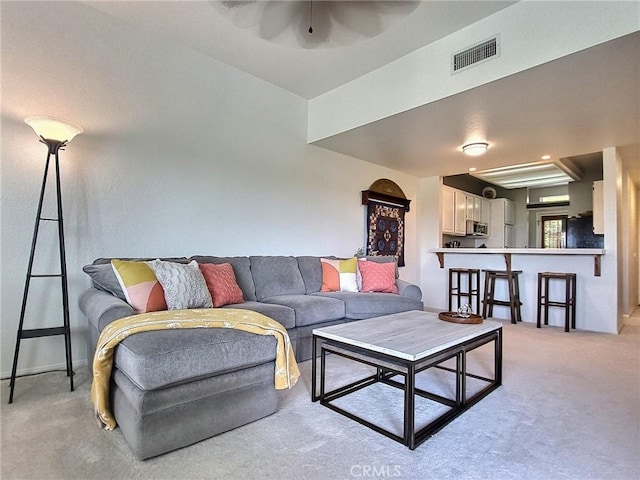 living room with light carpet, ceiling fan, and visible vents