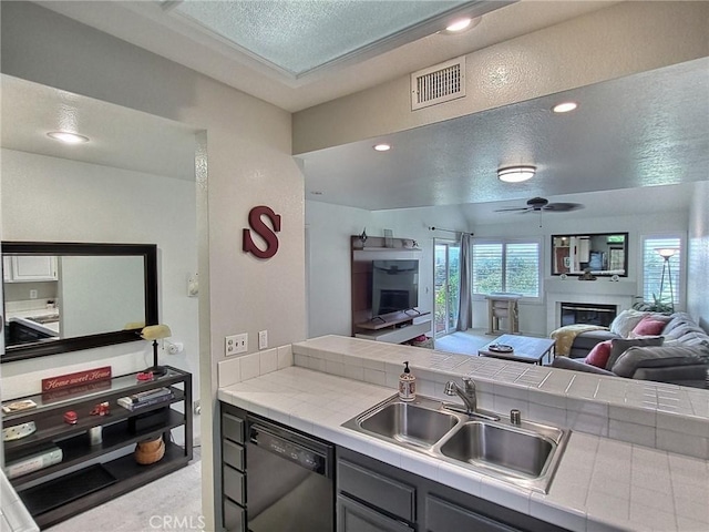 kitchen with tile countertops, visible vents, open floor plan, a sink, and dishwasher