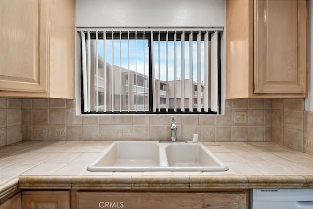 kitchen featuring tile counters, sink, and light brown cabinetry