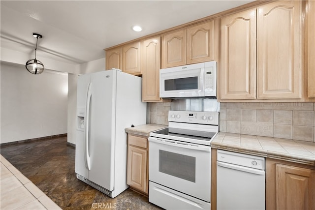 kitchen featuring white appliances, tile countertops, dark tile patterned floors, and backsplash