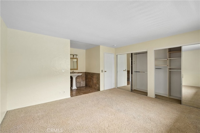 unfurnished bedroom featuring carpet flooring and two closets