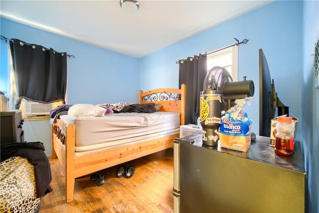 bedroom with cooling unit and hardwood / wood-style flooring