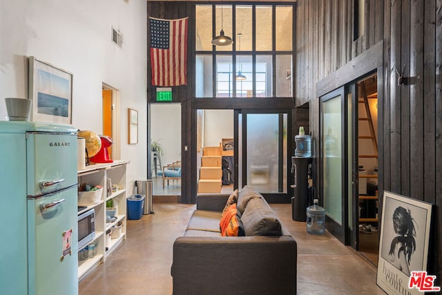 interior space with a high ceiling and concrete flooring