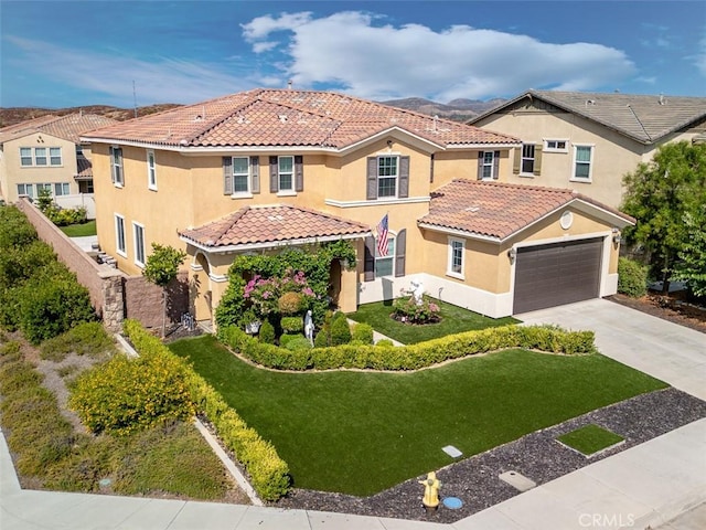 mediterranean / spanish-style home featuring a garage and a front lawn