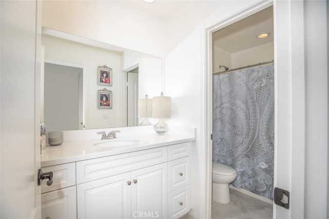 bathroom with toilet, vanity, and tile patterned flooring