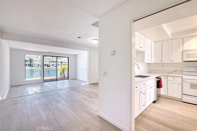 16090 Tortola Cir, Huntington Beach, CA 92649 - kitchen with white appliances, open floor plan, light wood-type flooring, and white cabinets