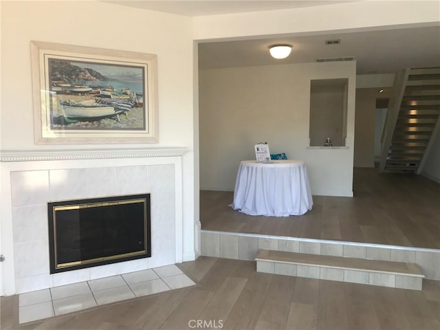 interior space featuring a tile fireplace and wood-type flooring