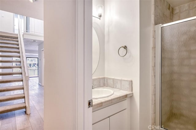 bathroom with hardwood / wood-style floors, vanity, and walk in shower