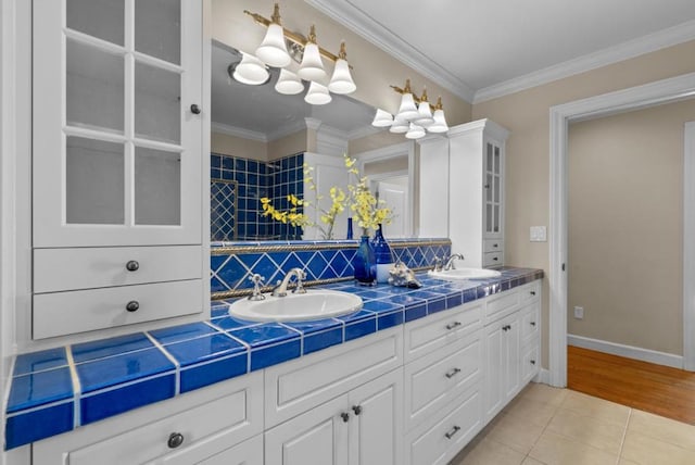 bathroom with tasteful backsplash, ornamental molding, tile patterned floors, and vanity