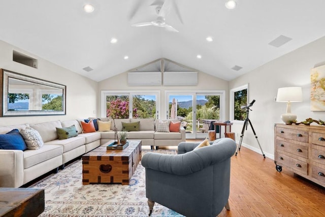 living room featuring vaulted ceiling, ceiling fan, and light hardwood / wood-style flooring