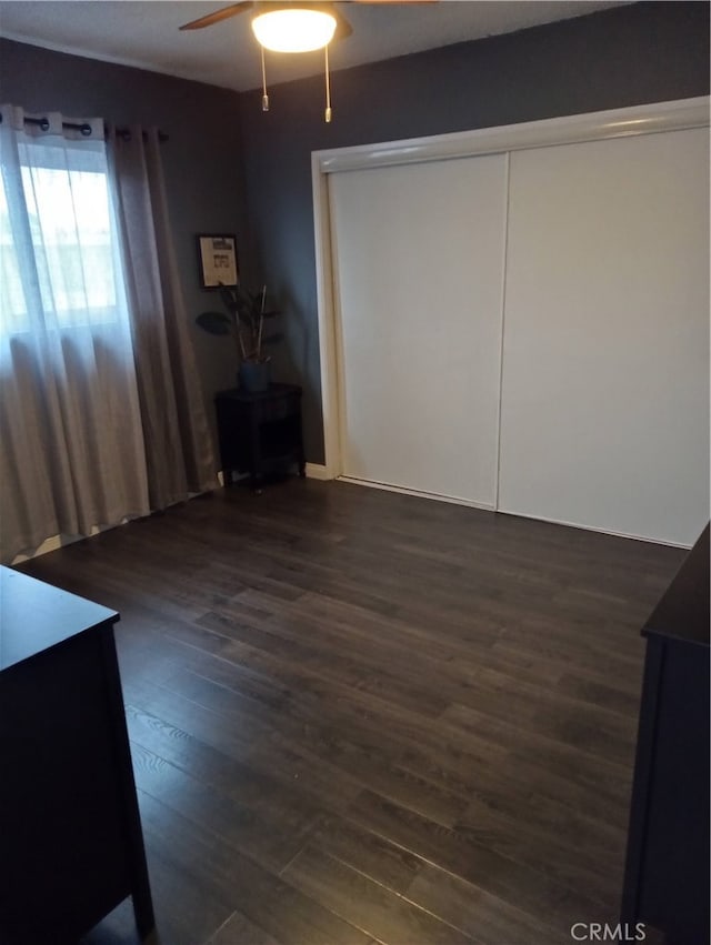 unfurnished bedroom with a closet, ceiling fan, and dark hardwood / wood-style floors