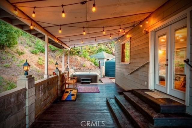 deck with french doors and a hot tub