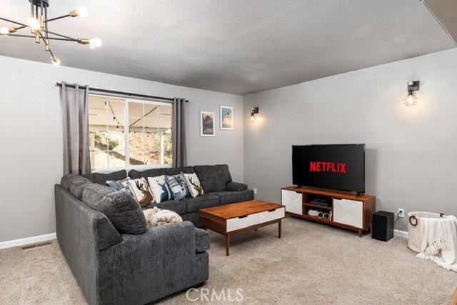 living room featuring light colored carpet and a chandelier