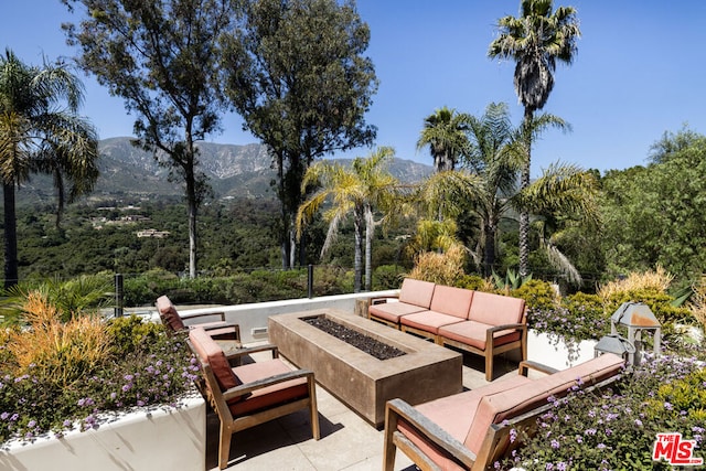 view of patio / terrace featuring a mountain view and an outdoor living space with a fire pit