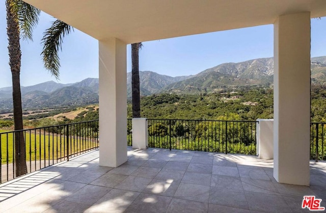 view of patio with a mountain view and a balcony