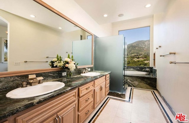 bathroom with tile patterned floors, a mountain view, vanity, and a bath