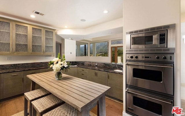 kitchen with kitchen peninsula, light wood-type flooring, and stainless steel appliances