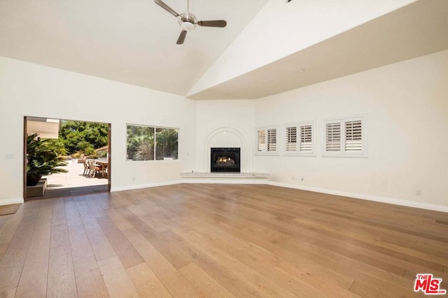 unfurnished living room featuring light wood-type flooring, high vaulted ceiling, and ceiling fan