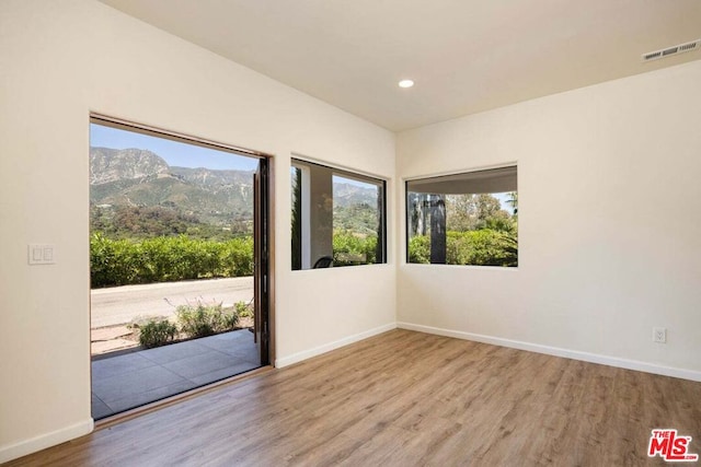 empty room with a mountain view and light hardwood / wood-style floors