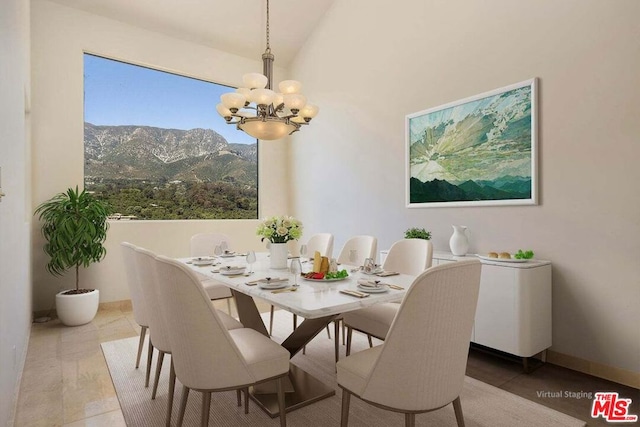 tiled dining room featuring a notable chandelier, a mountain view, and lofted ceiling