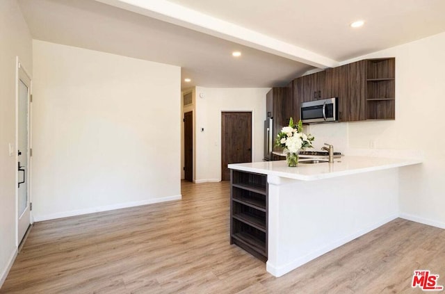 kitchen featuring kitchen peninsula, dark brown cabinetry, stainless steel appliances, sink, and light hardwood / wood-style floors