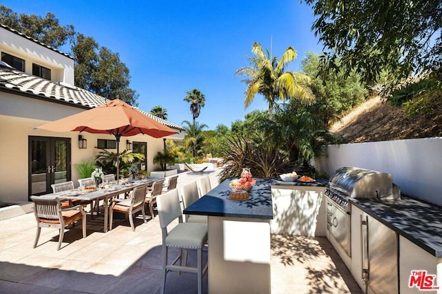 view of patio featuring area for grilling, french doors, and an outdoor kitchen