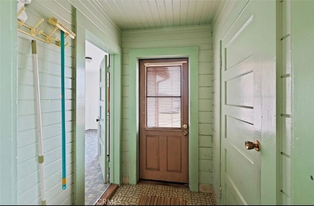 doorway with wood walls