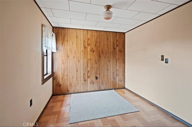 spare room with light parquet flooring and wooden walls