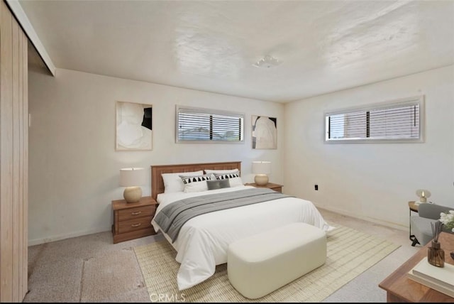 carpeted bedroom featuring a closet and multiple windows