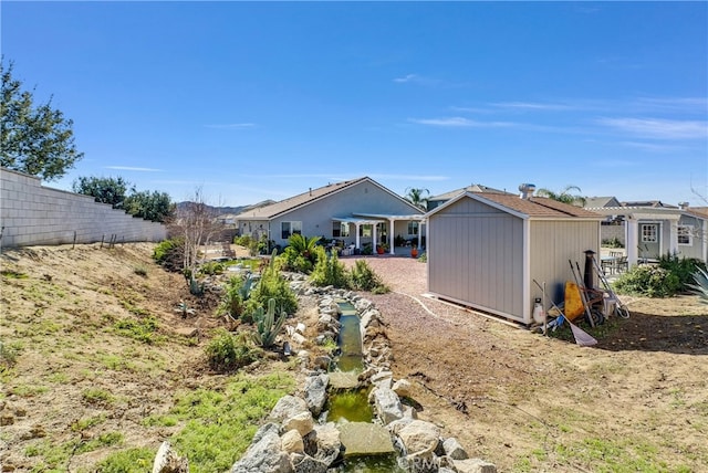 back of property with a shed and a patio area